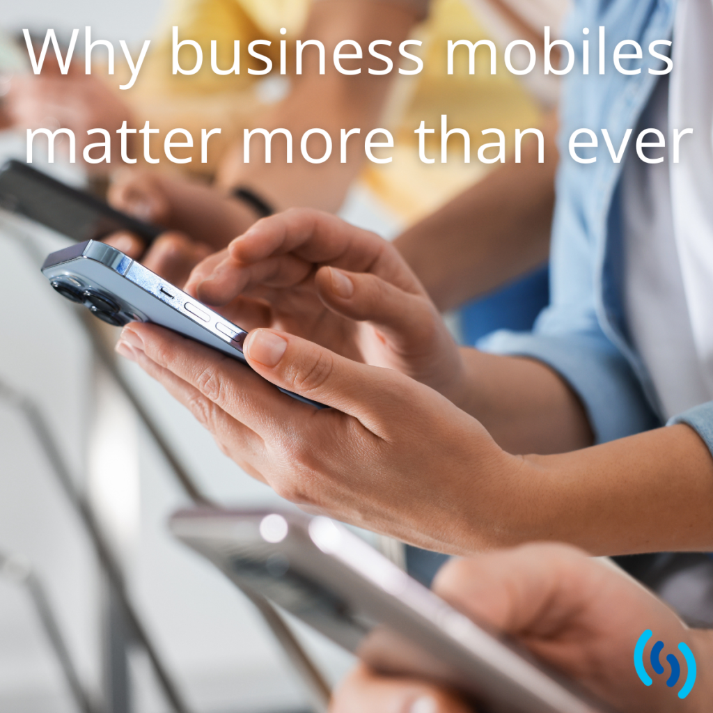 People using smartphones in a workplace setting, illustrating the importance of business mobiles for modern work.