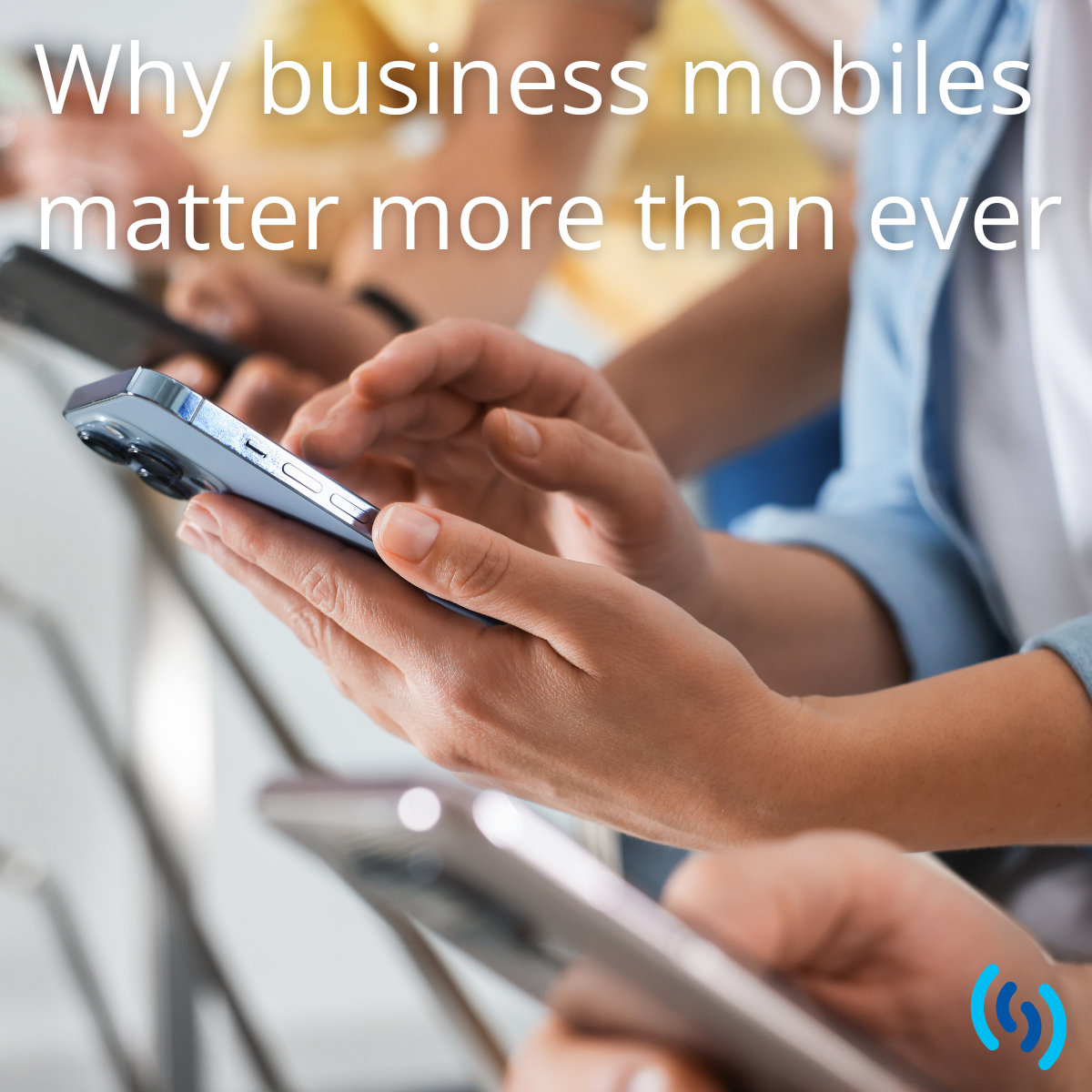 People using smartphones in a workplace setting, illustrating the importance of business mobiles for modern work.